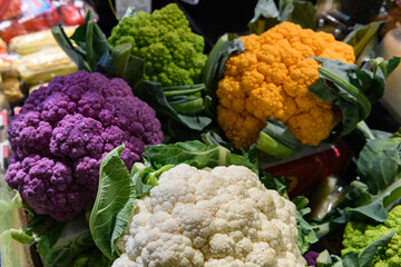 Multi-colored cauliflower at a farmer's market. Purple cauliflower is a hybrid variety containing the antioxidant anthocyanin, while the orange variety gets its color from beta-carotene.