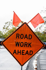 Orange, traffic warning sign alerting motor vehicles of road work ahead and to be prepared to stop.