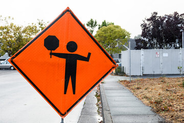 Orange, traffic warning sign alerting motor vehicles of road work ahead and to be prepared to stop.