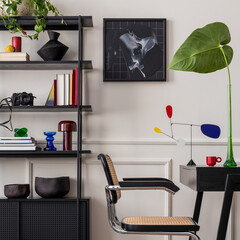 Workplace interior with mock up poster frame, black desk, rattan chair, stylish rack, books, yellow...