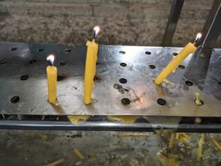 lit candles on a metal stand