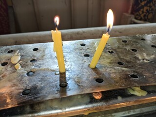 lit candles on a metal stand