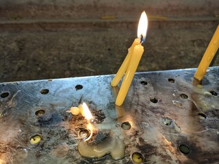 lit candles on a metal stand