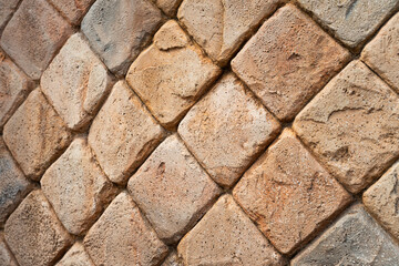 Sandstone surface in partel orange color tone with diamond cut square pattern. Background and texture with close-up photo.