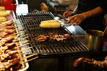 Delicious grilled squids and corns. Taiwanese street food at Taiwanese night markets or Seafood markets. 