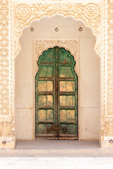 Green wooden door in Amber Fort, Jaipur, Rajasthan, India.