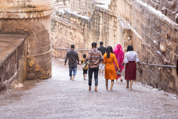 A group of hindu people leaving Amber Fort in a rainy day