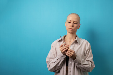 Bald woman in striped shirt and sports top holding syringe, representing chemotherapy, medicine preparation, and patient care.