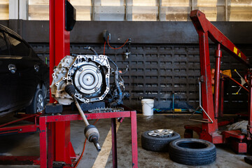 Disassembled automatic transmission and drive axle laid out on a cart in an auto repair workshop....