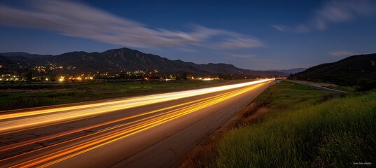 Streaks of light from vehicles on a highway at dusk