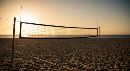 Beach volleyball net silhouetted against a warm, golden sunset on sandy shore