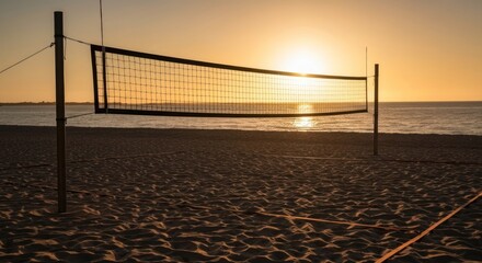 Beach volleyball net silhouetted against a bright, golden sunset over the ocean
