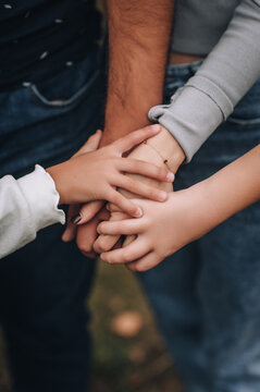 Family, man and woman, son and daughter holding hands together.