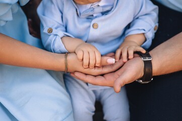 Obraz premium Photo of happy family, little child, father and mother holding hands.