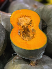 Close-up of halved pumpkin showing vibrant orange flesh and seeds, autumn harvest season. Concept of Thanksgiving food, organic produce and healthy seasonal eating