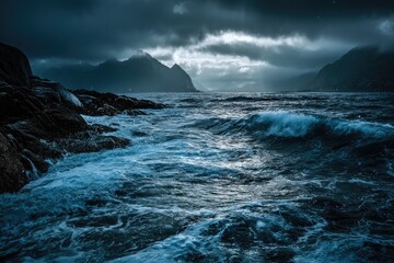 Dramatic seascape with rough waves crashing against rocky shore under stormy skies and distant mountains.