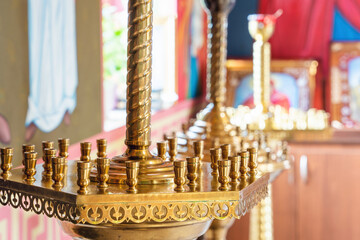 Golden candlesticks in an Orthodox church with blurred background and icons