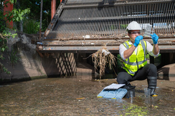Water quality engineer collect water samples at the irrigation entrance, science is inspecting water