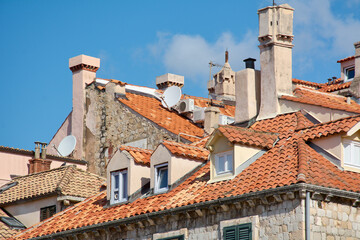 A close-up of dense terracotta rooftops, chimneys, and dormers in Dubrovniks Old Town. Satellite dishes are mixed with the historic architecture.