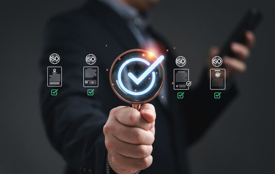 Quality and approve concept showing a businessman holding magnifying glass with check mark representing certification standard control assurance validation and business reliability in modern industry