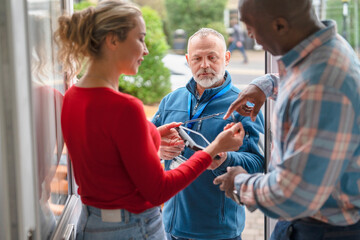 Obraz premium People discussing information at the entrance of a building during daylight hours