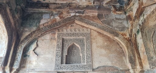 Intricately Carved Stucco Ceiling and Arches of Bada Gumbad Mosque in Delhi Showcasing Islamic Geometric Patterns and Calligraphic Art