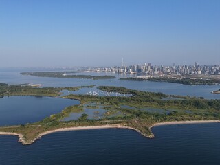 Aerial view of Toronto Tommy Thompson Park Islands and Lake Ontario skyline in clear summer light. g. © Artem Onoprienko