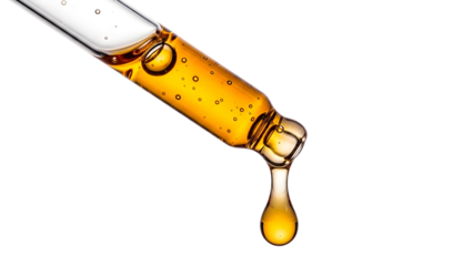 Close-up of golden liquid dripping from a glass pipette serum or oil for cosmetic and pharmaceutical use isolated on 