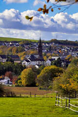 Blick vom Waldrand auf den Ort Riegelsberg mit dem Kirchturm von St. Josef nahe Saarbrücken, Saarland