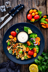 Grilled chicken breast, mayonnaise and vegetables on wooden table. Top view