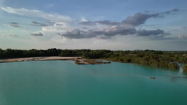 bintan islands blue lagoon also known as danau biru features striking turquoise waters surrounded by white sand hills creating a stunning contrast and serene tropical atmosphere