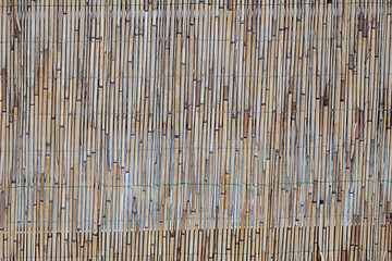 Bamboo fence wall with vertical slats creating natural pattern and warm rustic texture
