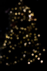 Soft golden bokeh lights create a festive holiday glow against a dark background