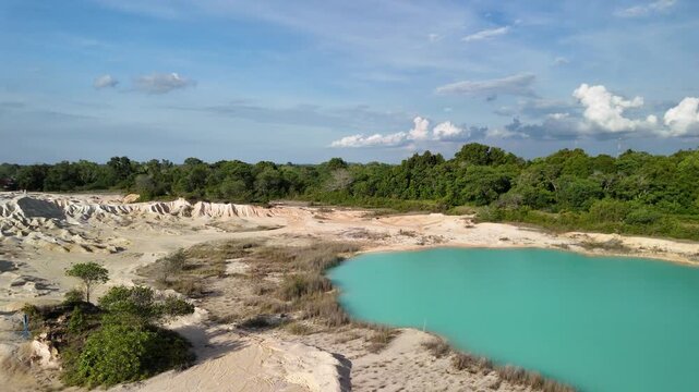 bintan islands blue lagoon also known as danau biru features striking turquoise waters surrounded by white sand hills creating a stunning contrast and serene tropical atmosphere