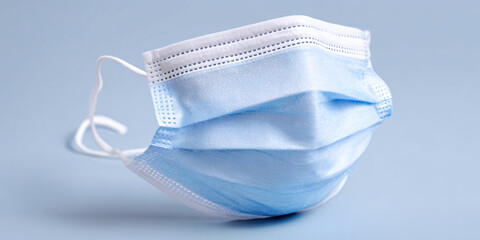 A person wearing a protective face mask in a public urban setting for safety and health during daily commute or travel