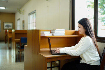 Girl studying with laptop in university class