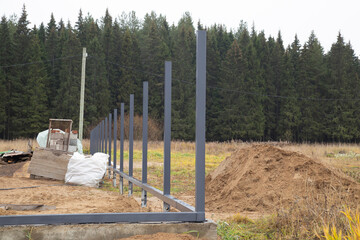 Installation of a fence around the house. Posts made of iron.