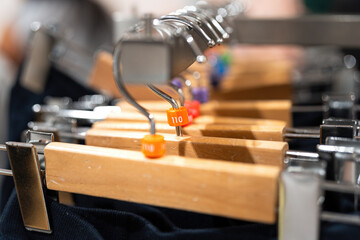 Close-up at cloth hanger that hanging on the railing with various sizing number that for kid size. 