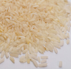 Uncooked Long-Grain Rice Spread on White Surface