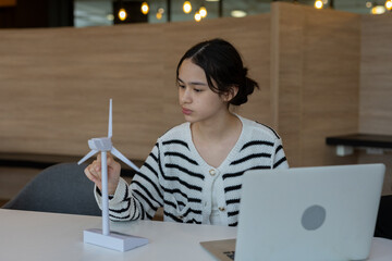 female student studying renewable energy with wind turbine model, promoting green technology, sustainability and environmental STEM education for future innovation.