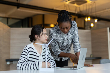 Teacher guiding young student in renewable energy project using wind turbine model, promoting STEM education, sustainability and hands on environmental learning. © eakgrungenerd