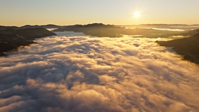 A tranquil and serene sunrise occurs over a beautiful sea of clouds