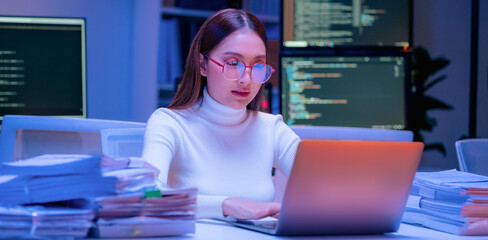 Asian female smart programmer works late night office coding deep learning AI models, training neural networks with intense concentration and focus, dedicating overtime hours alone to machine learning