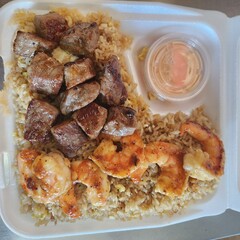Assorted Grilled Meats, Shrimp, Vegetables, and Rice in Takeout Container with Sweet Sauce
