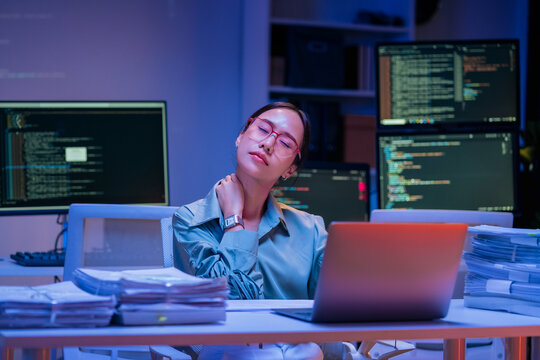 Asian female smart programmer works late night office coding deep learning AI models, training neural networks with intense concentration and focus, dedicating overtime hours alone to machine learning