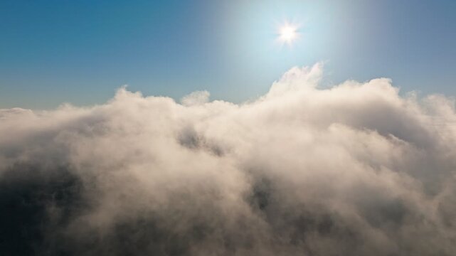 A Serene and Beautiful Sky Above the Fluffy Clouds with Bright Sunlight