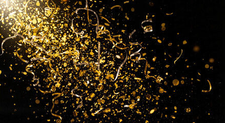 Gold confetti falling on black background celebrating party atmosphere