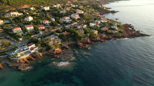 Aerial panoramic view of the Esterel Mountains near Saint Raphael, French Riviera, showing the Mediterranean Sea and luxury villas along the Cote dAzur coastline in the warm sunrise light