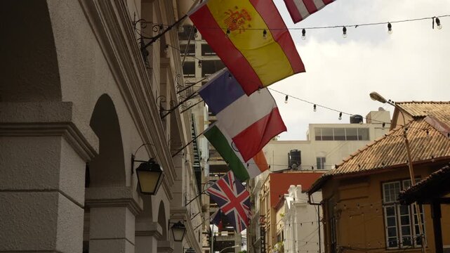 International flags hanging on historic city street with European architecture, global culture and travel concept