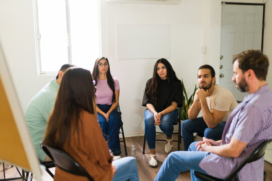 Hispanic people participating in mental health support group - Powered by Adobe